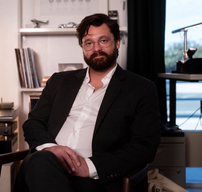 Taylor E. DeRosa seated in his office among records and books